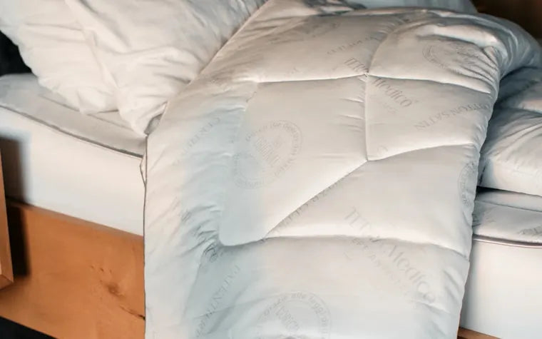 Das BETTER³ Anti-Stress-Oberbett liegt gesteppt auf einem Bett